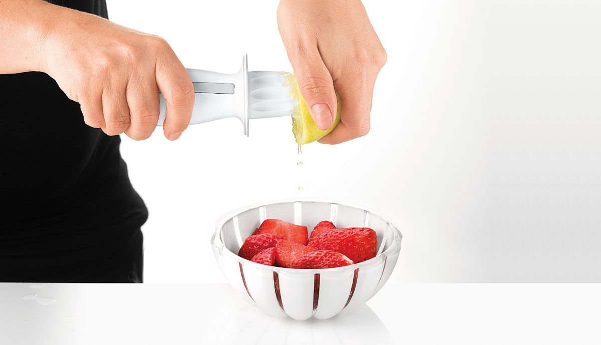 Squeezing a lemon with the Guzzini juicer over a bowl