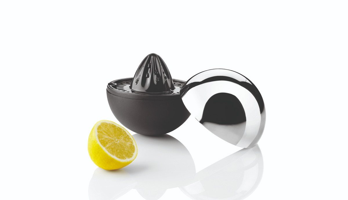 Stelton Rise &rsquo;n&rsquo; Shine juicer open with polished steel cover and half a lemon